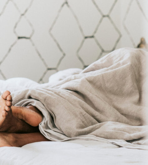 Black couple with their feet under the blanket