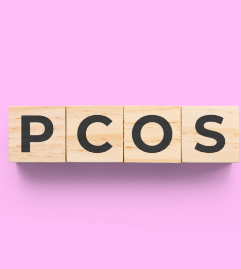 PCOS (Polycystic Ovary Syndrome) wooden cubes on pink background